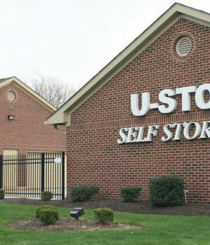 Well-lit self-storage facility hallway with modern security cameras mounted on ceiling, symbolizing safety guarantee.